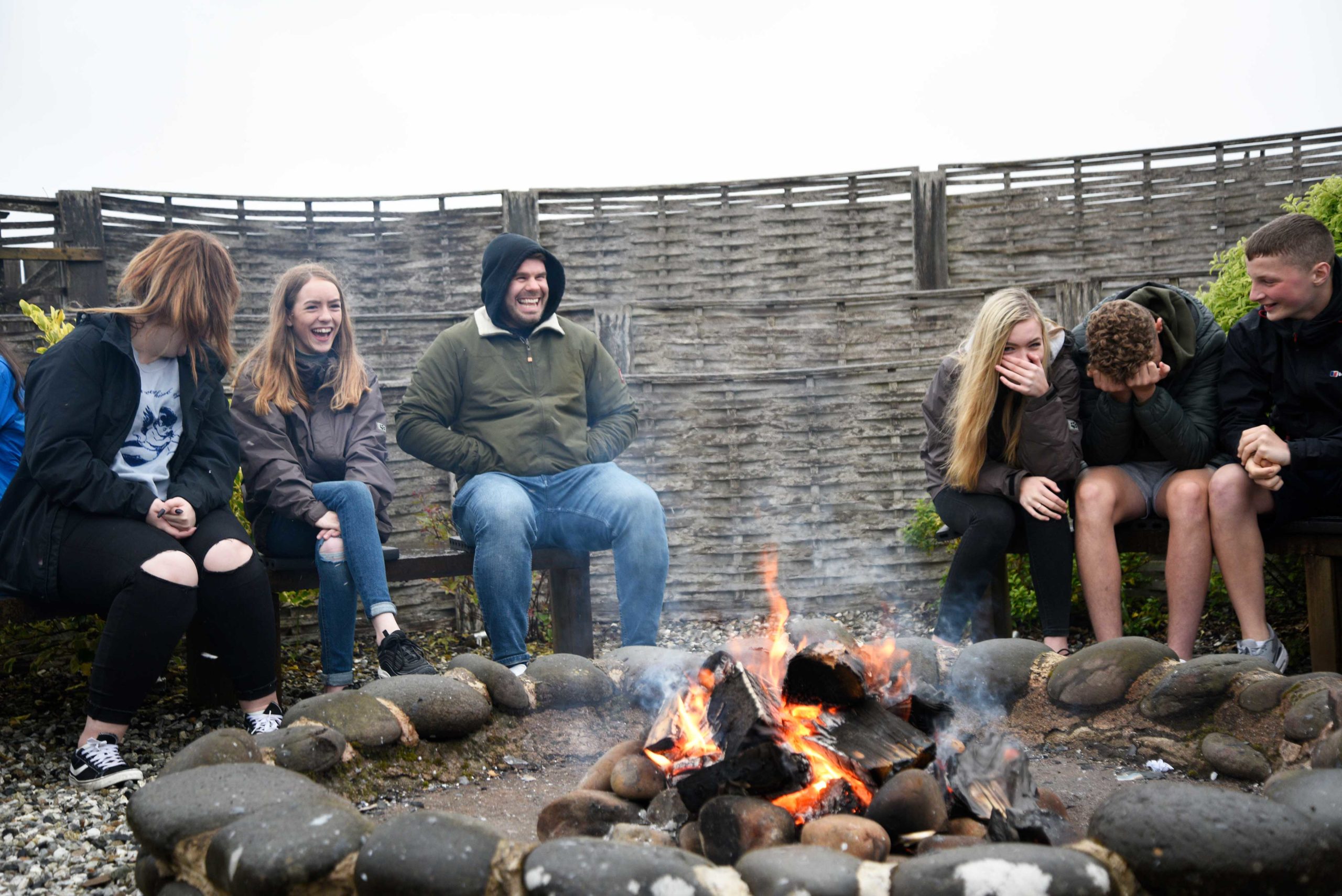 Group laughing around a campfire