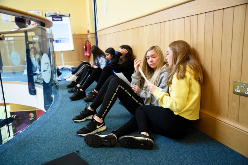 Young people sitting on the floor discussing ideas