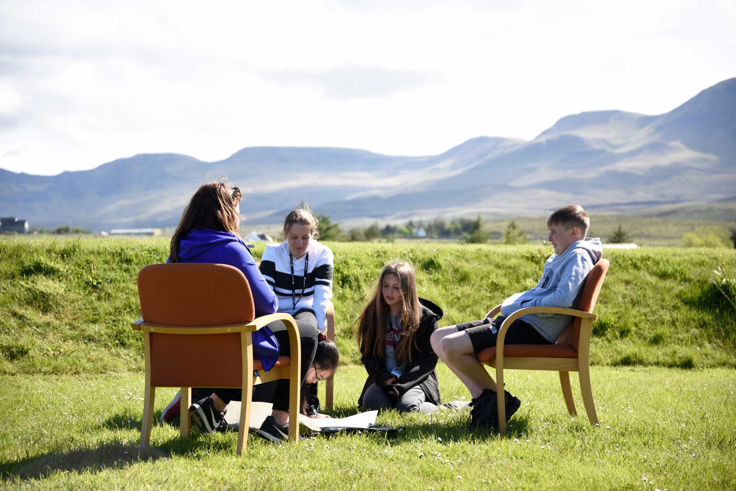 Group of four outside on Skye looking at something on the ground