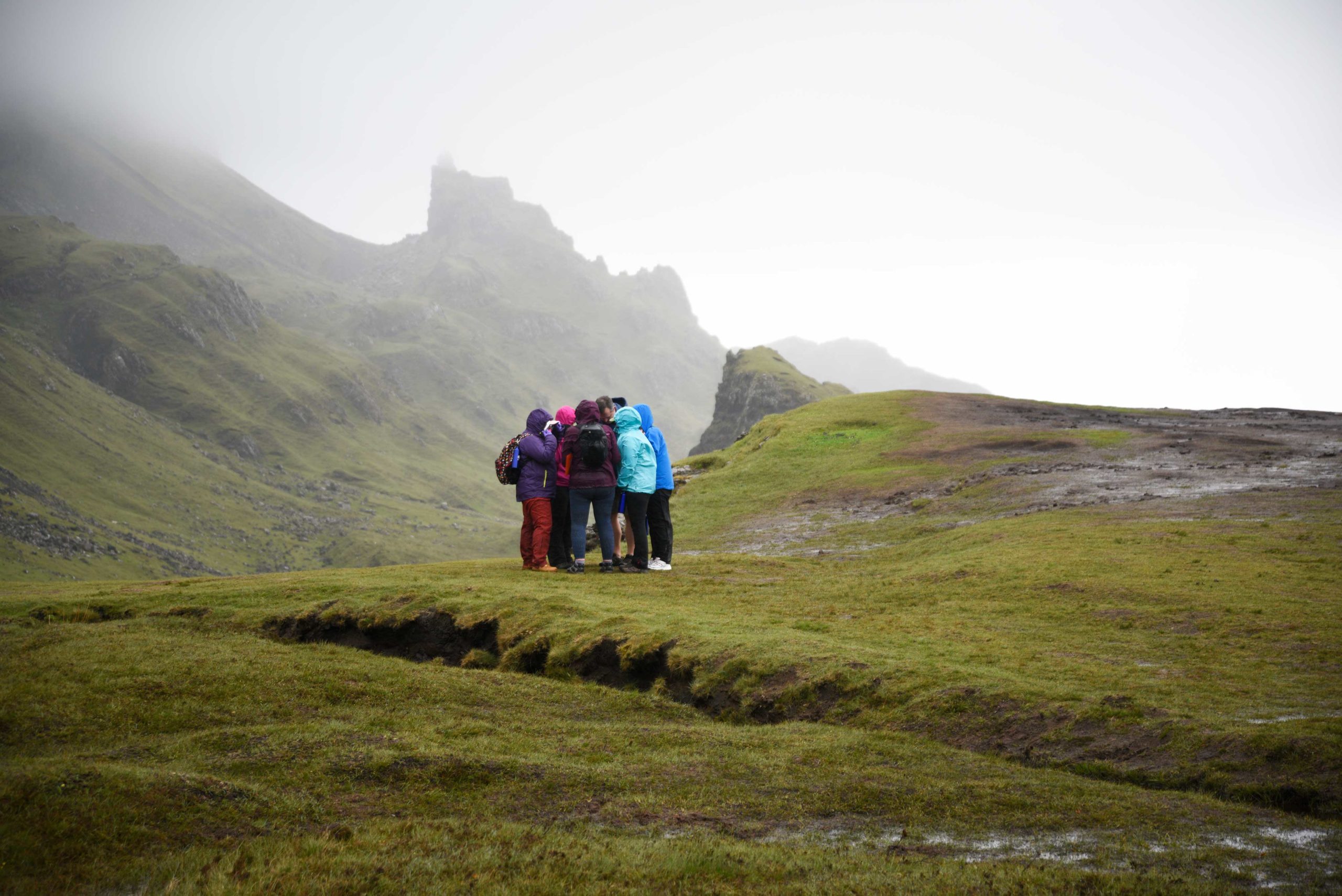 Group huddled close together outside on foggy Skye