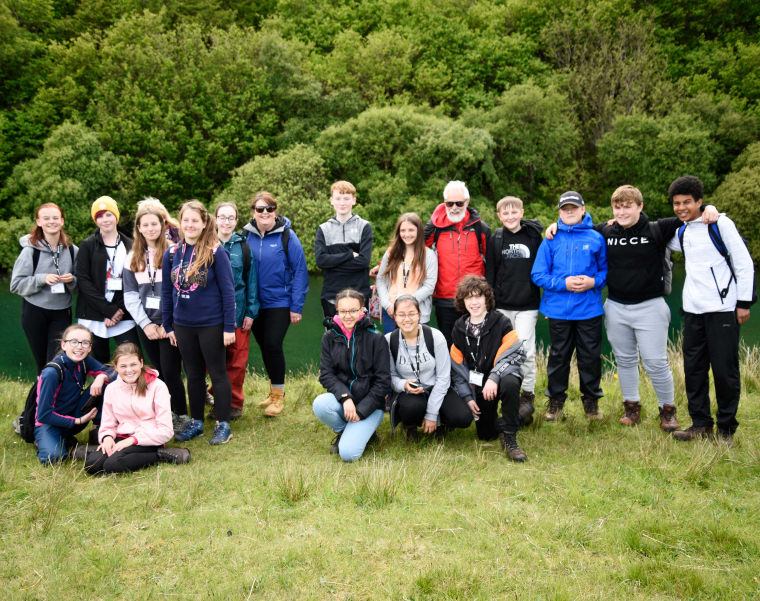 Group of teenagers posing for picture outside