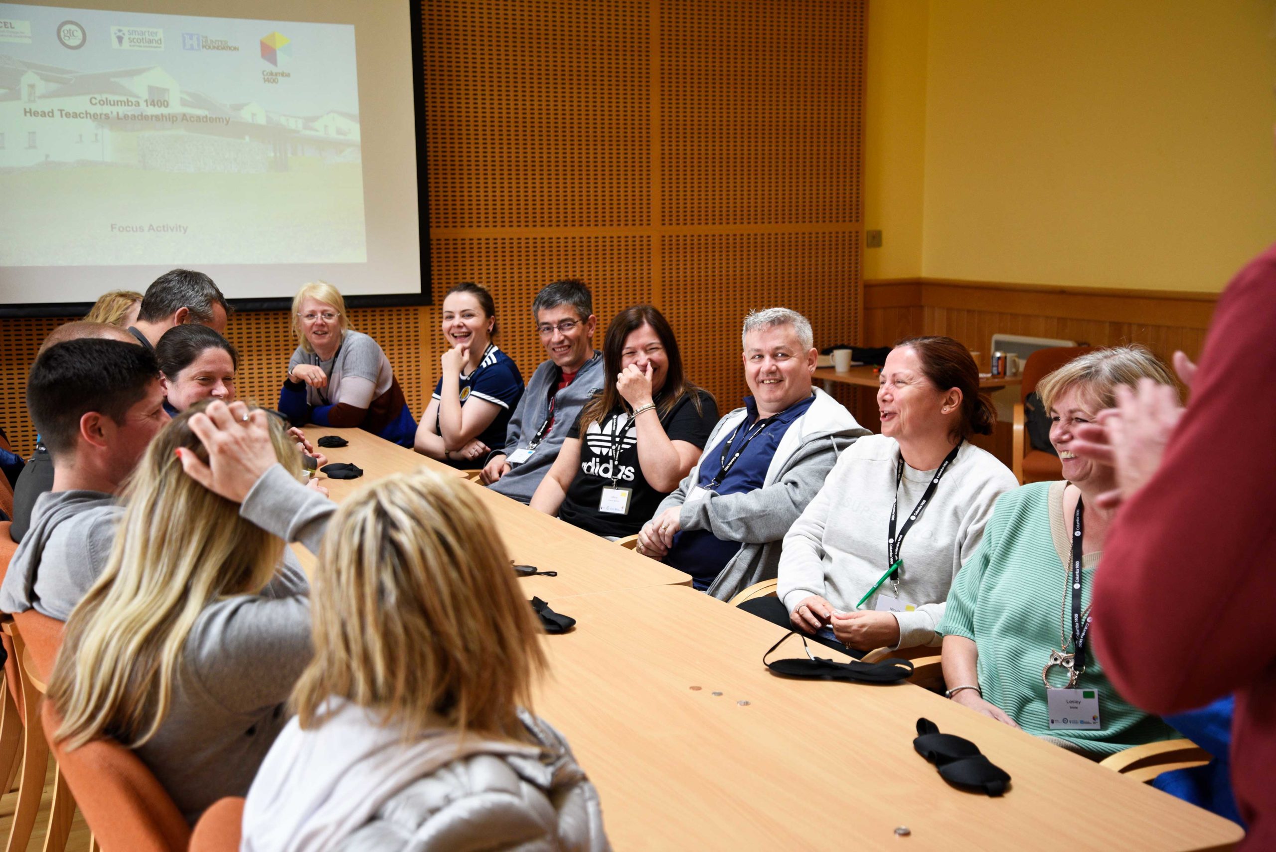 Group of adults in happy discussion around a long table